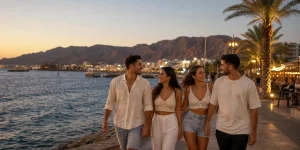 צעירים מעל גיל 18 מטיילים בטיילת אילת בשעת השקיעה