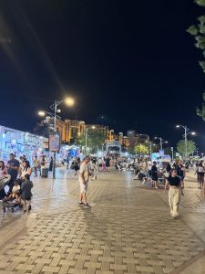 מטיילים, דוכנים ומלונות לאורך טיילת החוף הצפוני באילת בשעות הערב