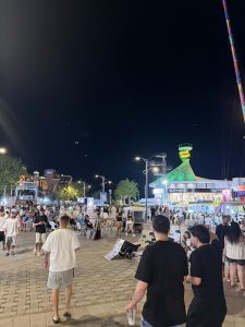 מטיילים ודוכנים מוארים בטיילת אילת בשעות הלילה