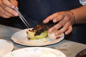 השף נוף שלי מסדר מנת כרוב על צלחת בפרויקט משותף עם חוף הדקל
